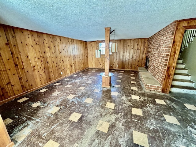 basement with wooden walls and a textured ceiling