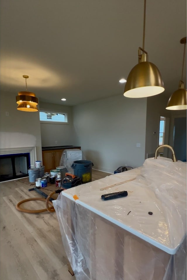 kitchen featuring hanging light fixtures, hardwood / wood-style flooring, and a fireplace