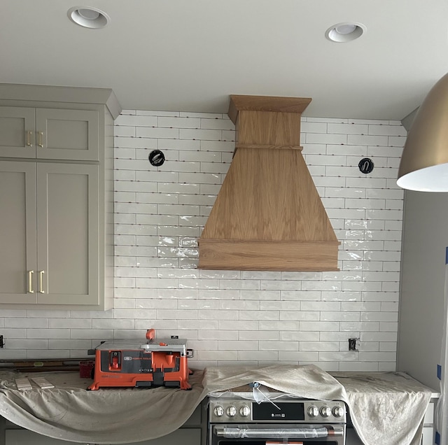 kitchen with gray cabinets, premium range hood, backsplash, and electric stove