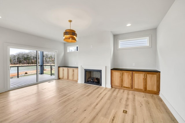 unfurnished living room with a fireplace, recessed lighting, visible vents, light wood-type flooring, and baseboards