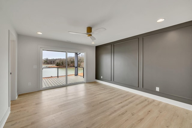 spare room featuring light wood-type flooring, a decorative wall, recessed lighting, and ceiling fan