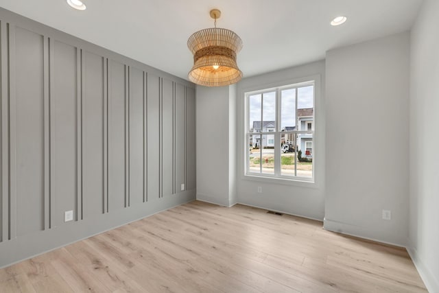 empty room with light wood-type flooring, visible vents, and recessed lighting