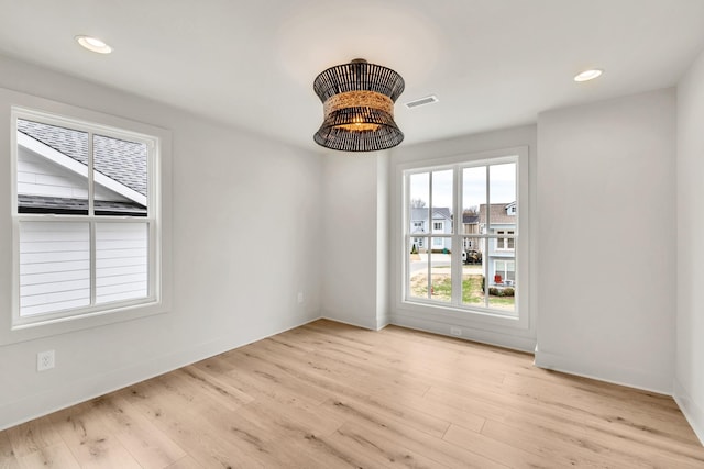 unfurnished room featuring baseboards, wood finished floors, visible vents, and recessed lighting