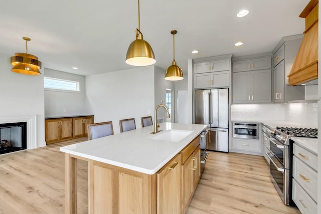 kitchen with stainless steel appliances, a sink, light countertops, backsplash, and custom range hood