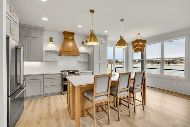 kitchen with tasteful backsplash, custom range hood, appliances with stainless steel finishes, gray cabinets, and light countertops