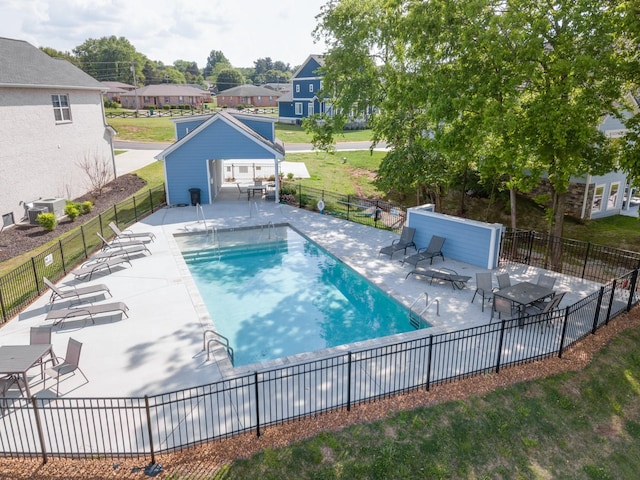 pool featuring cooling unit, a patio area, fence, and a residential view