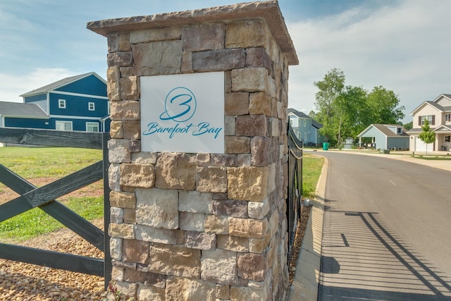 community sign with a residential view and fence