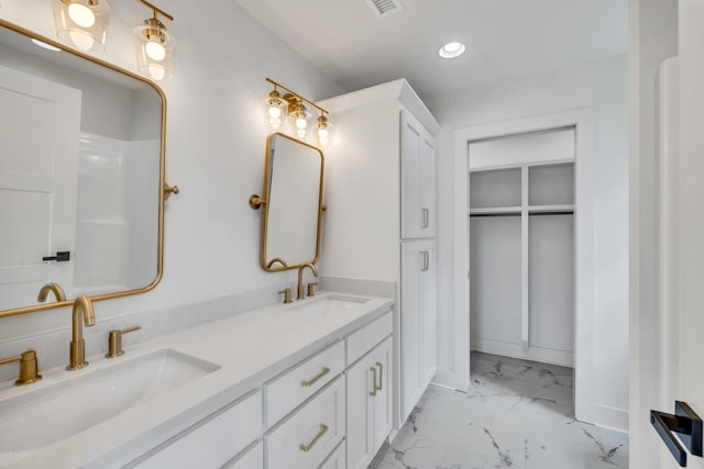 bathroom with recessed lighting, marble finish floor, a sink, and double vanity