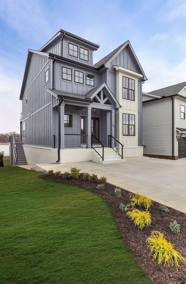 modern farmhouse with driveway, board and batten siding, and a front yard