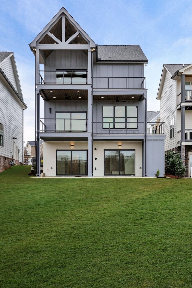 rear view of house featuring a yard and a balcony