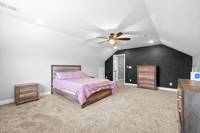 carpeted bedroom featuring ceiling fan, vaulted ceiling, and a textured ceiling