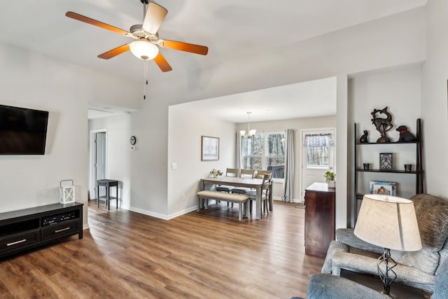 living room featuring ceiling fan with notable chandelier and hardwood / wood-style floors