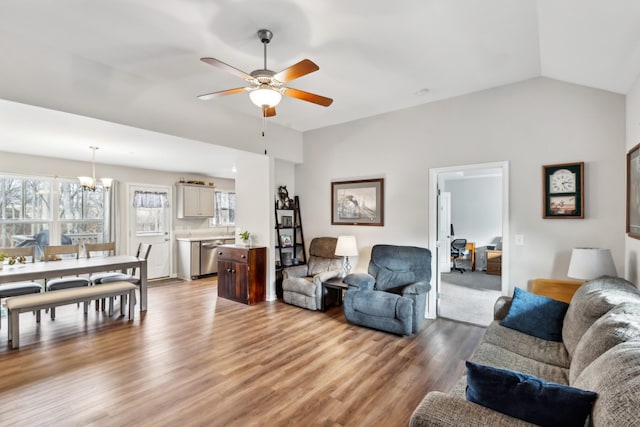 living room featuring lofted ceiling, ceiling fan with notable chandelier, and wood-type flooring