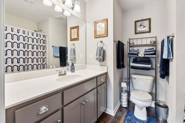 bathroom with vanity, toilet, and hardwood / wood-style floors