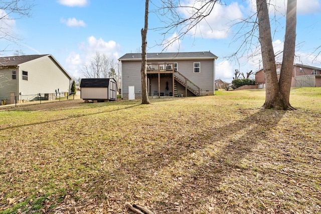 back of house with a storage shed, a deck, and a lawn