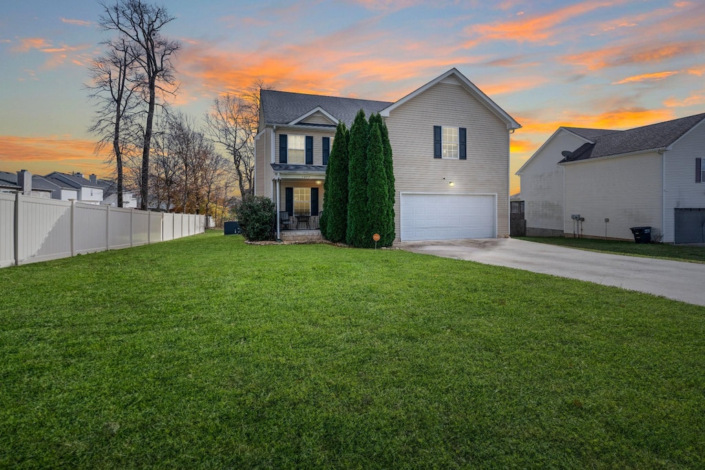 view of front of home with a garage and a lawn