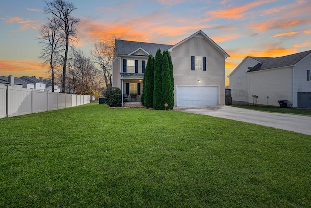 view of front of home with a garage and a lawn