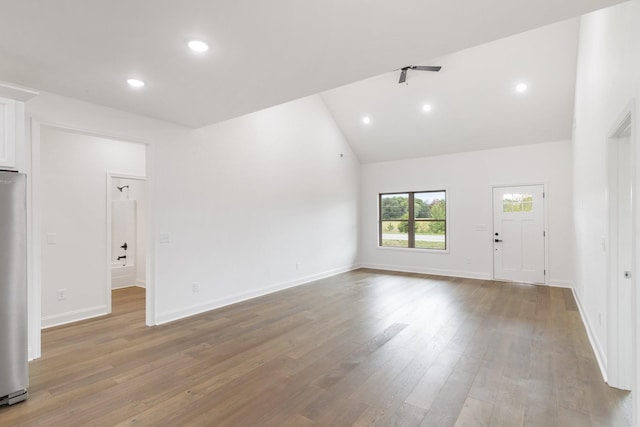 empty room with hardwood / wood-style flooring and high vaulted ceiling