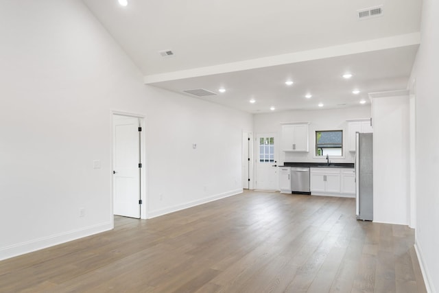 unfurnished living room featuring sink and wood-type flooring