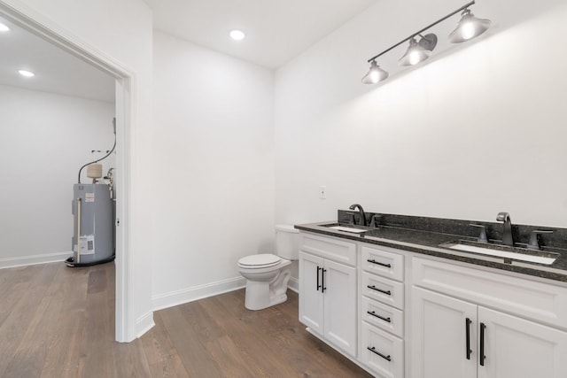 bathroom with vanity, toilet, electric water heater, and hardwood / wood-style floors