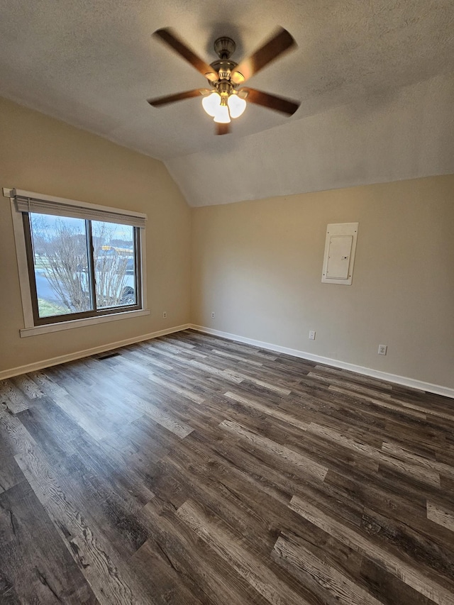 unfurnished room featuring ceiling fan, dark hardwood / wood-style floors, a textured ceiling, and lofted ceiling