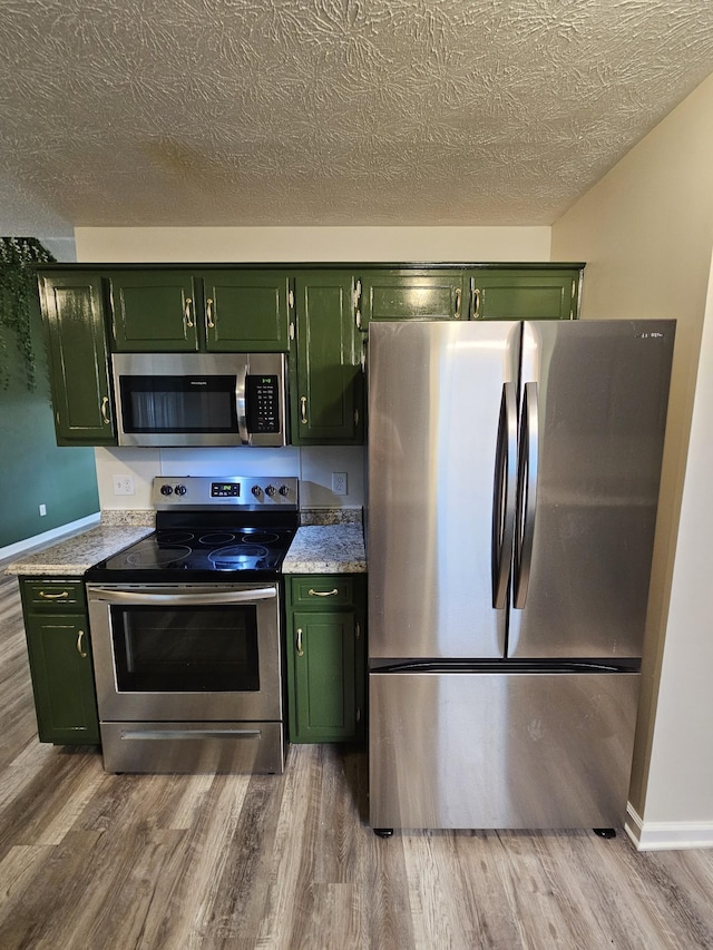 kitchen featuring stainless steel appliances and green cabinetry