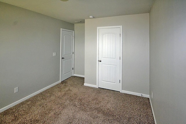 unfurnished bedroom with dark carpet