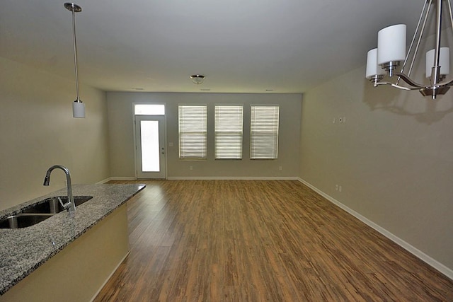 unfurnished living room featuring sink and dark wood-type flooring