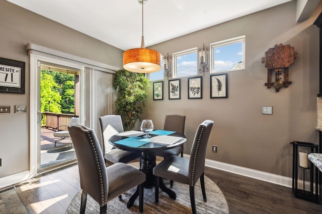 dining space featuring a healthy amount of sunlight, dark wood finished floors, and baseboards