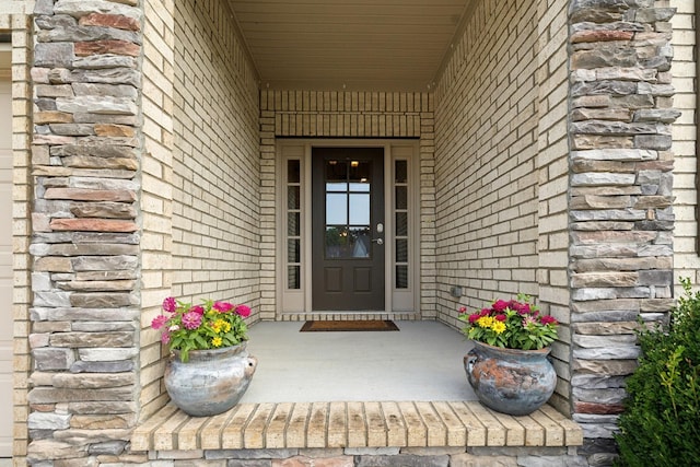 doorway to property with stone siding and brick siding