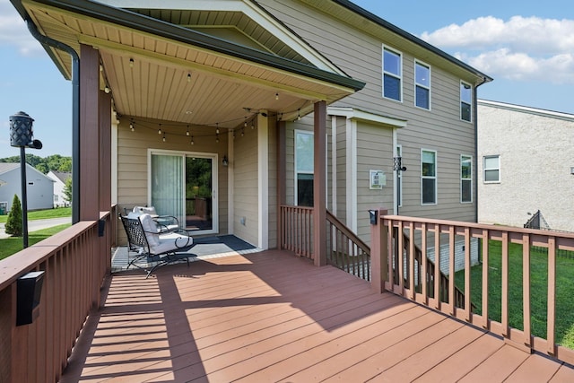 wooden terrace featuring a lawn