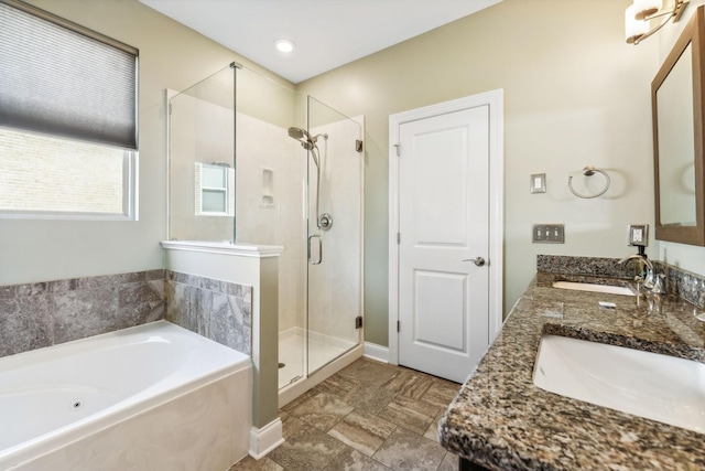 full bathroom featuring double vanity, a stall shower, a sink, and a bath