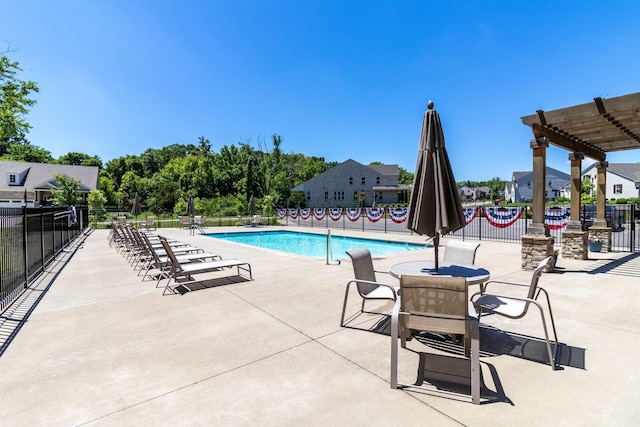 pool with a patio area and fence