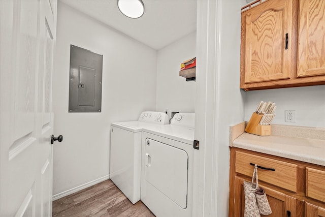 laundry area featuring cabinets, light hardwood / wood-style flooring, electric panel, and independent washer and dryer