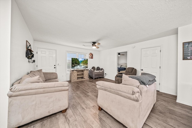 living room with ceiling fan, hardwood / wood-style floors, and a textured ceiling