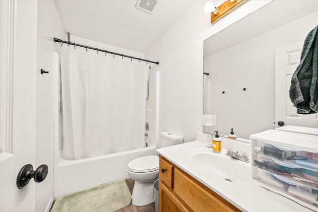 full bathroom featuring vanity, toilet, a textured ceiling, and shower / bath combo