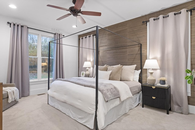 carpeted bedroom featuring multiple windows and ceiling fan