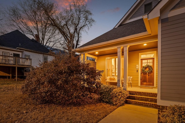 exterior entry at dusk featuring a porch