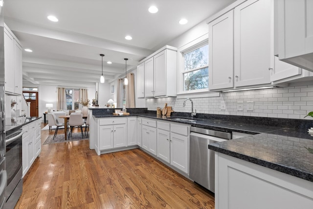 kitchen featuring pendant lighting, white cabinetry, hardwood / wood-style flooring, and appliances with stainless steel finishes