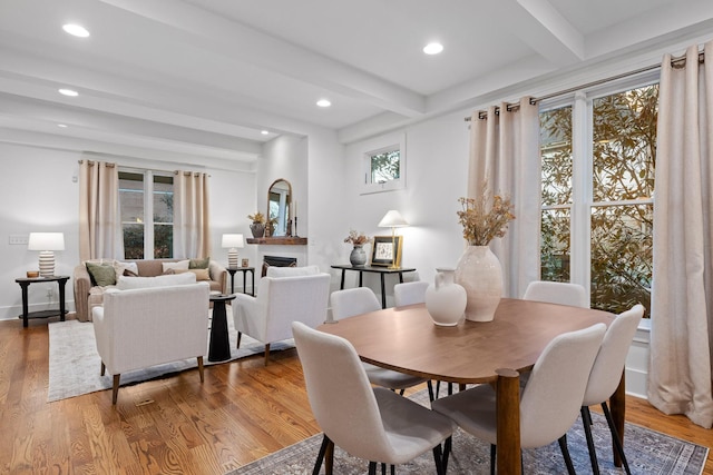 dining space featuring beam ceiling and light hardwood / wood-style flooring