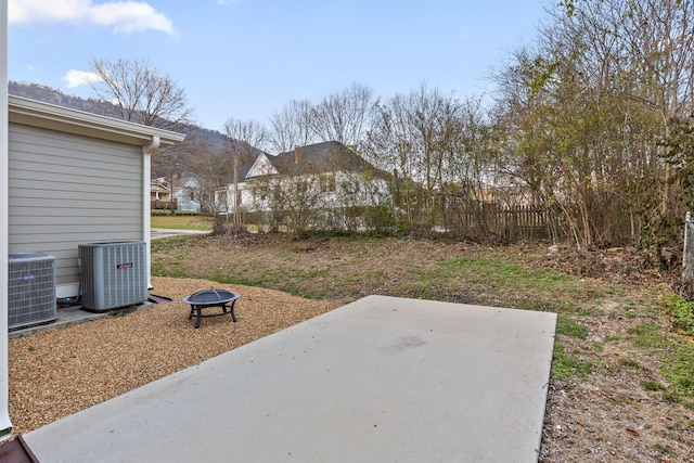 view of yard with a patio, central air condition unit, and a fire pit