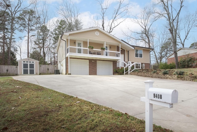 view of front of home featuring a garage, central air condition unit, and a shed