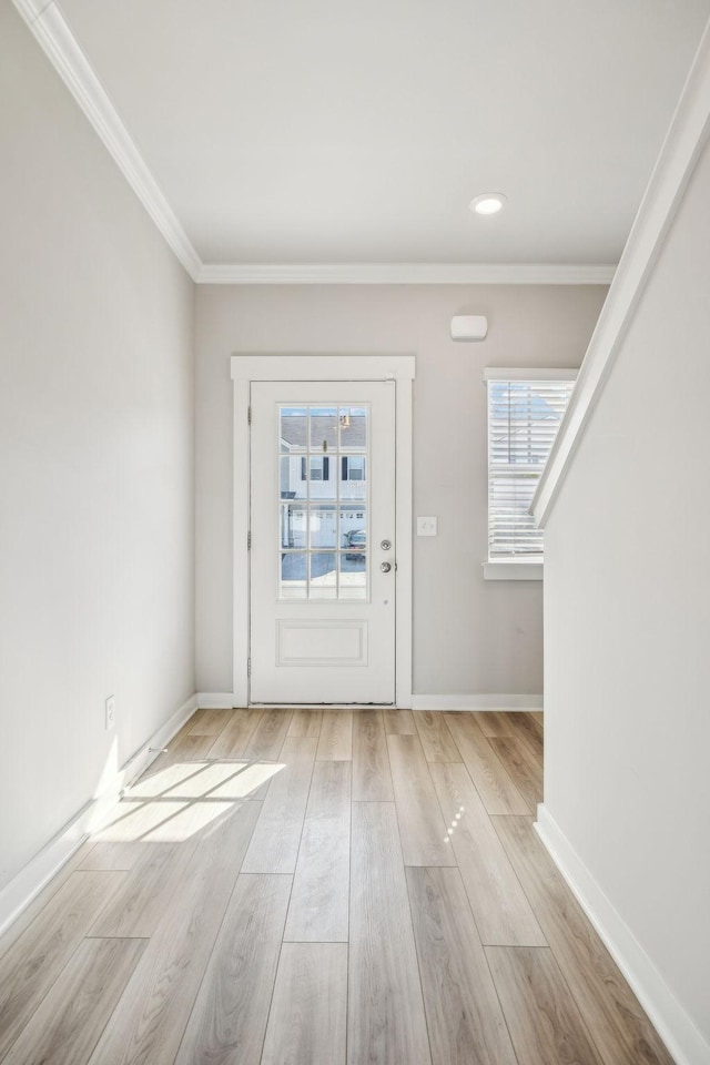 entryway with crown molding and light hardwood / wood-style flooring