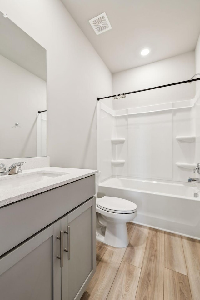 full bathroom featuring vanity, toilet, shower / washtub combination, and hardwood / wood-style floors