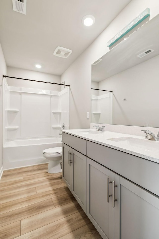 full bathroom with vanity, hardwood / wood-style floors, bathing tub / shower combination, and toilet