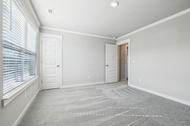 empty room with crown molding and carpet