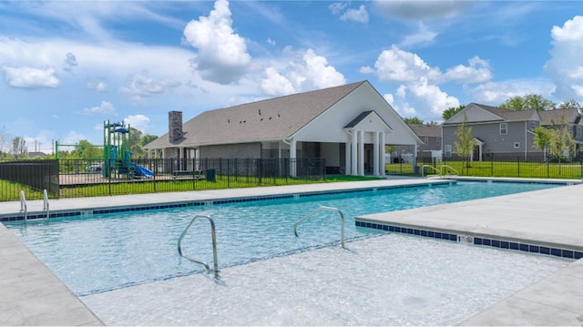 view of pool with a playground, a patio area, and a lawn