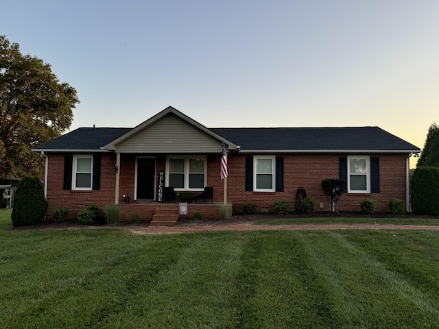 single story home featuring covered porch and a lawn