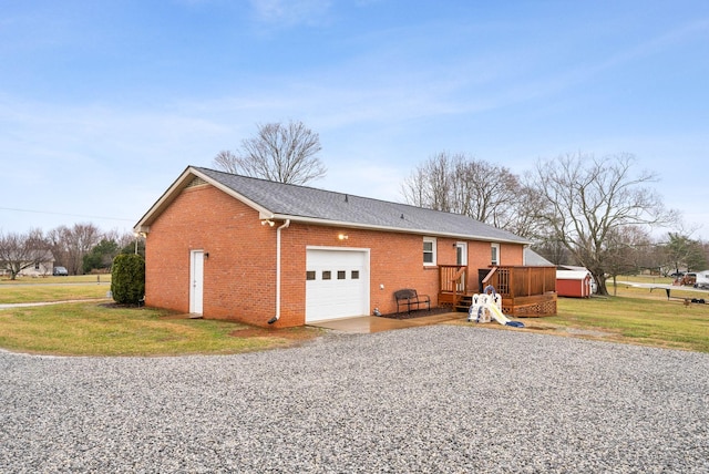 view of side of property featuring a garage, a wooden deck, and a lawn