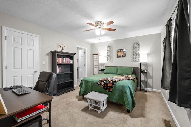 bedroom with ceiling fan, carpet flooring, and a textured ceiling